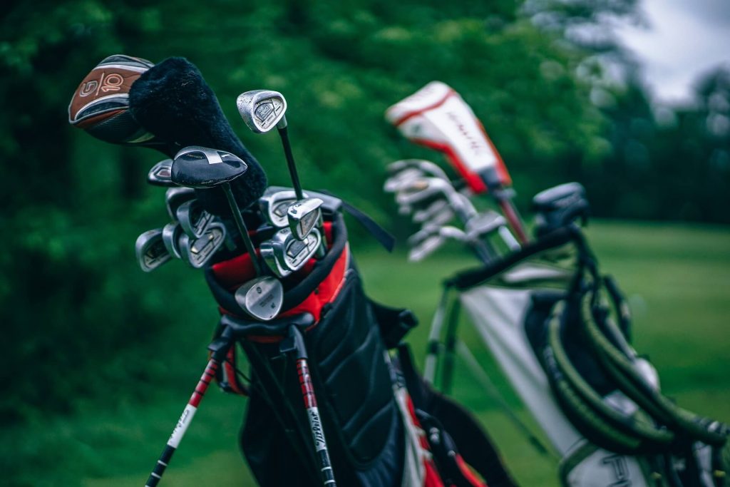 two sets of used golf clubs on course
